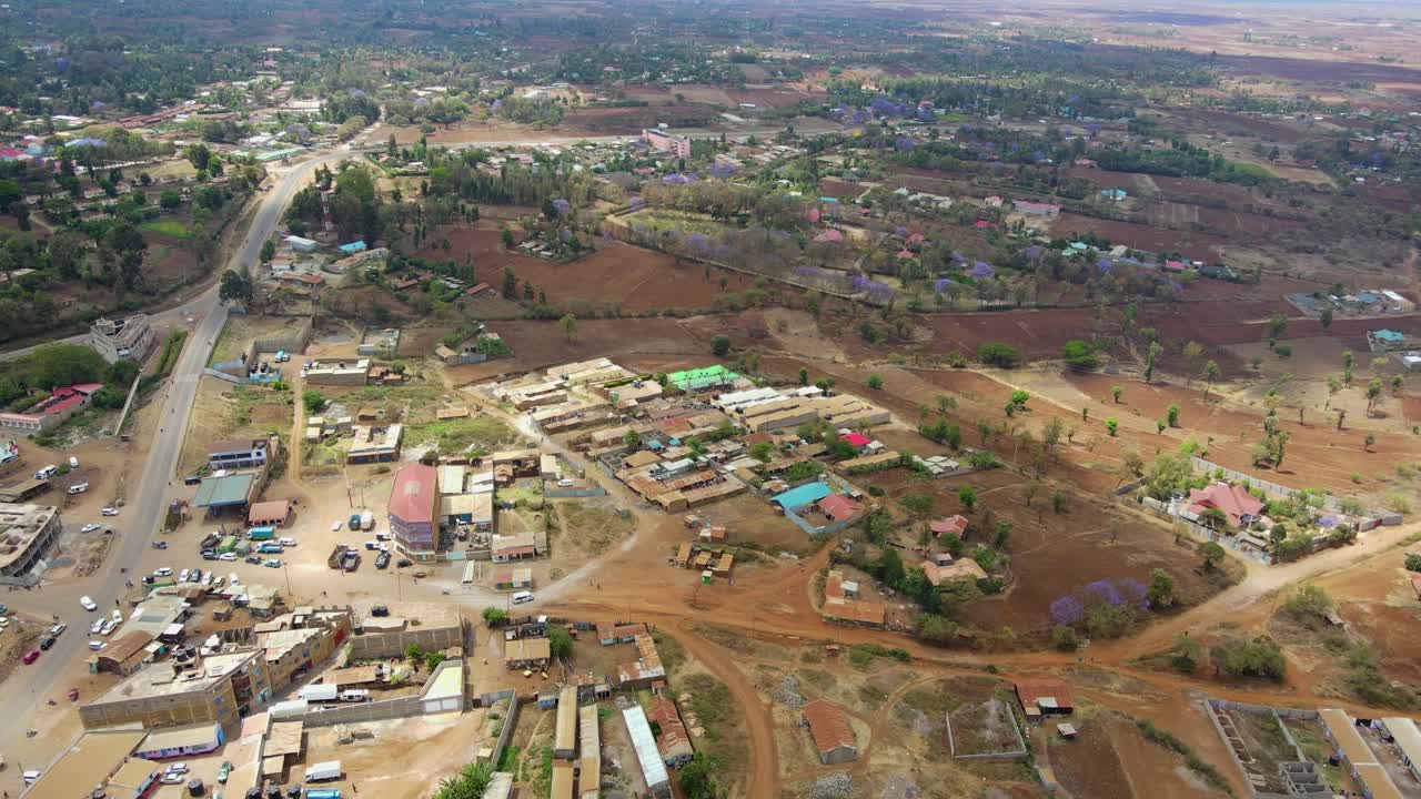 Vista aerea di una città e campi illuminati dal sole, ora d'oro nell'Africa rurale - ripresa in tracking con drone