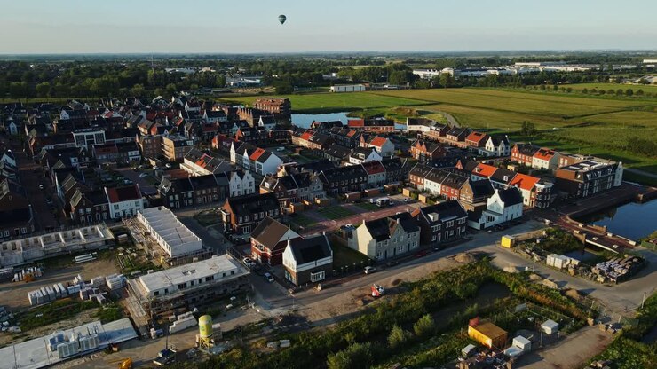 Veduta aerea di una città di nuova costruzione con una mongolfiera in lontananza