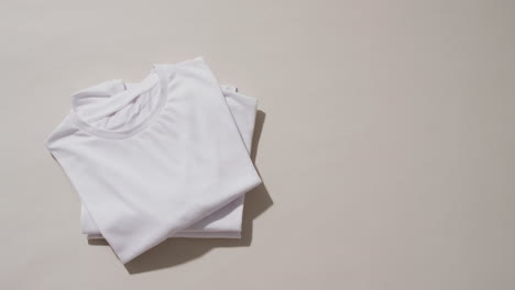 video de una pila de camisetas blancas plegadas con espacio de copia en un fondo blanco