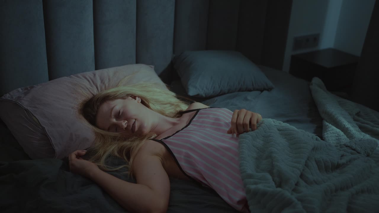 밤에 침대에서 자고 있는 여자