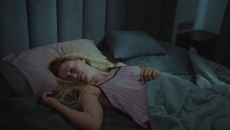 mujer durmiendo en la cama por la noche