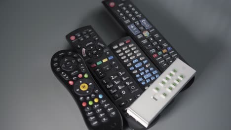 mans hands choosing a remote control from a table