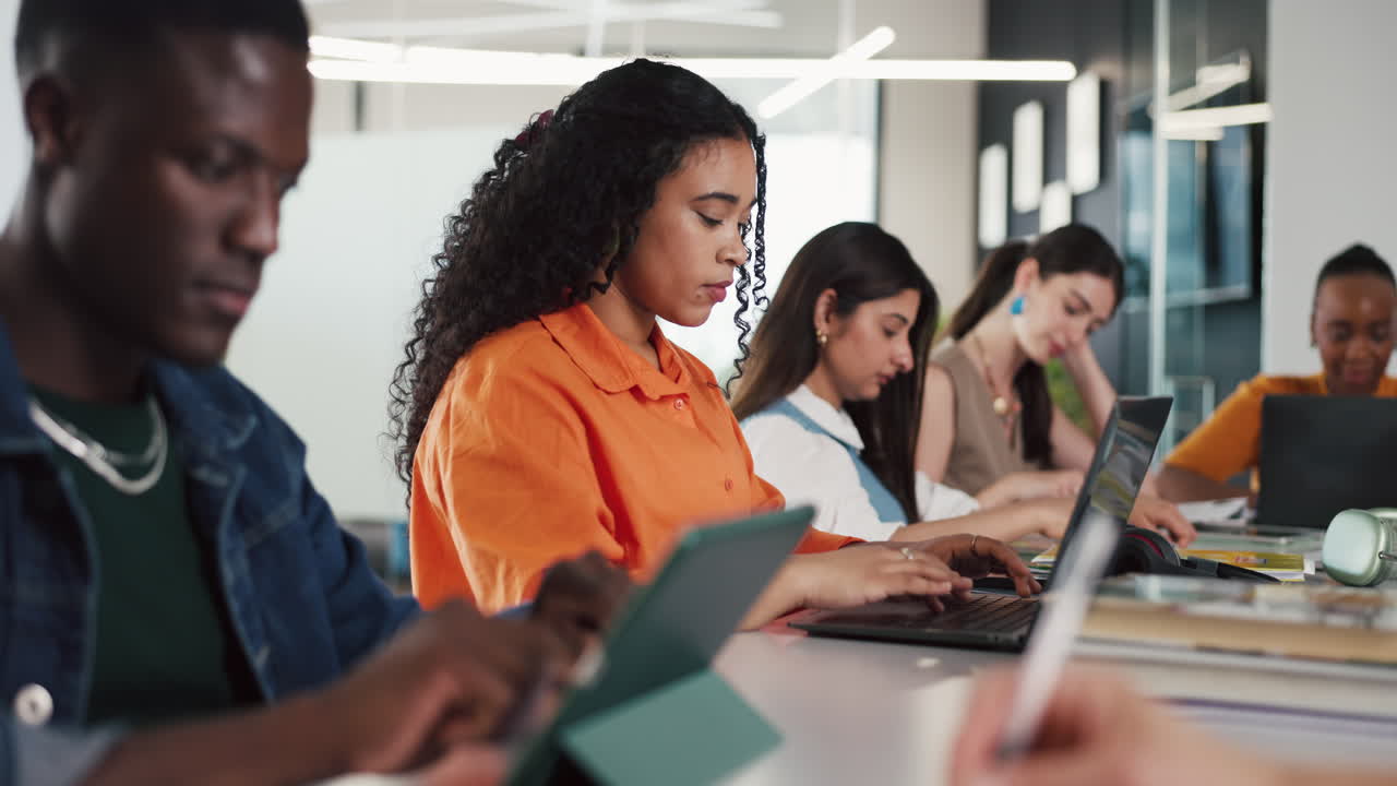 Diverse Group of Young Adults Working on Laptops and Tablets