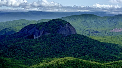cinematic drone footage of a lone, towering mountain emerging from the landscape