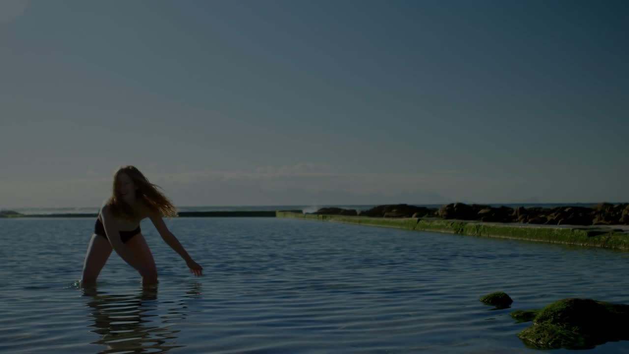 Woman kneeling in pool shifting weight and summoning pink energy, advancing toward camera tech demo