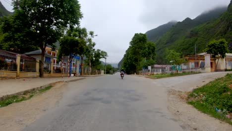 first person view of a narrow winding rough road that cuts through the mountains and valleys of northern vietnam