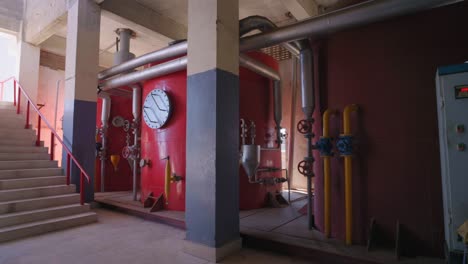 red industrial tanks with pipelines and control panel in a karachi factory