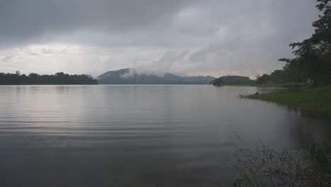 Tranquilo-Lago-Brumoso-Con-Montañas-En-La-Distancia