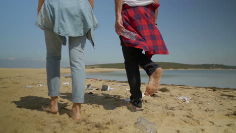 Paar-Wirft-Plastikflaschen-Am-Strand