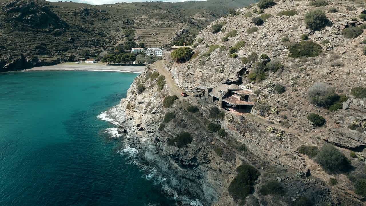 Aerial view approaching stone house built on the coastal cliff of Cap de Creus national park, Catalonia, Spain