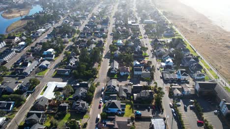 4K-aerial-drone-shot-floating-over-houses-at-Seaside,-Oregon-beach-on-sunny-afternoon