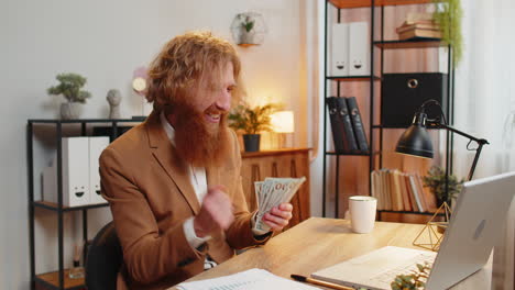 excited businessman counting cash money dollar checking salary enjoy richness in home office room