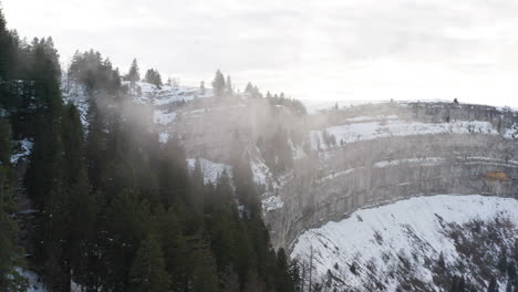 Drohne-Fliegt-Durch-Dünne-Wolken-In-Schneebedeckten-Bergen