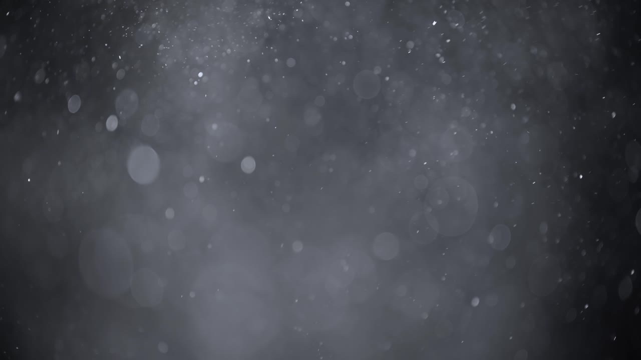 Floating abstract particle bokeh on dark background