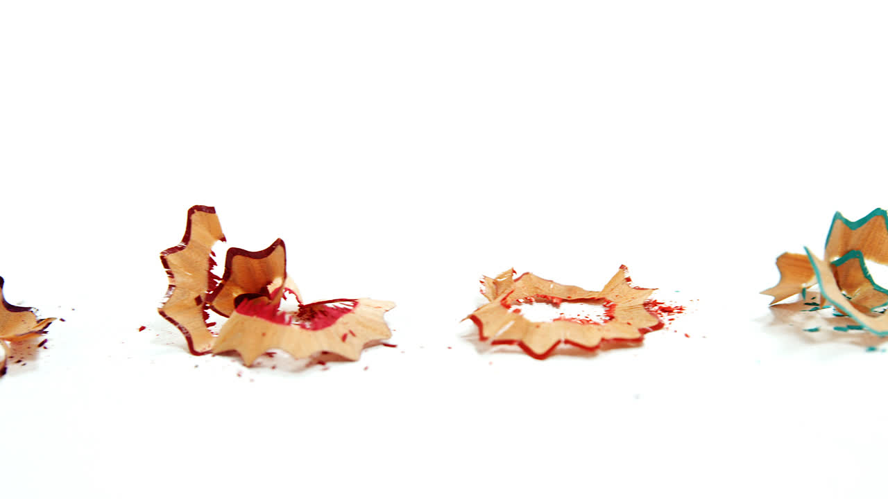 Colored pencil shavings on wooden background