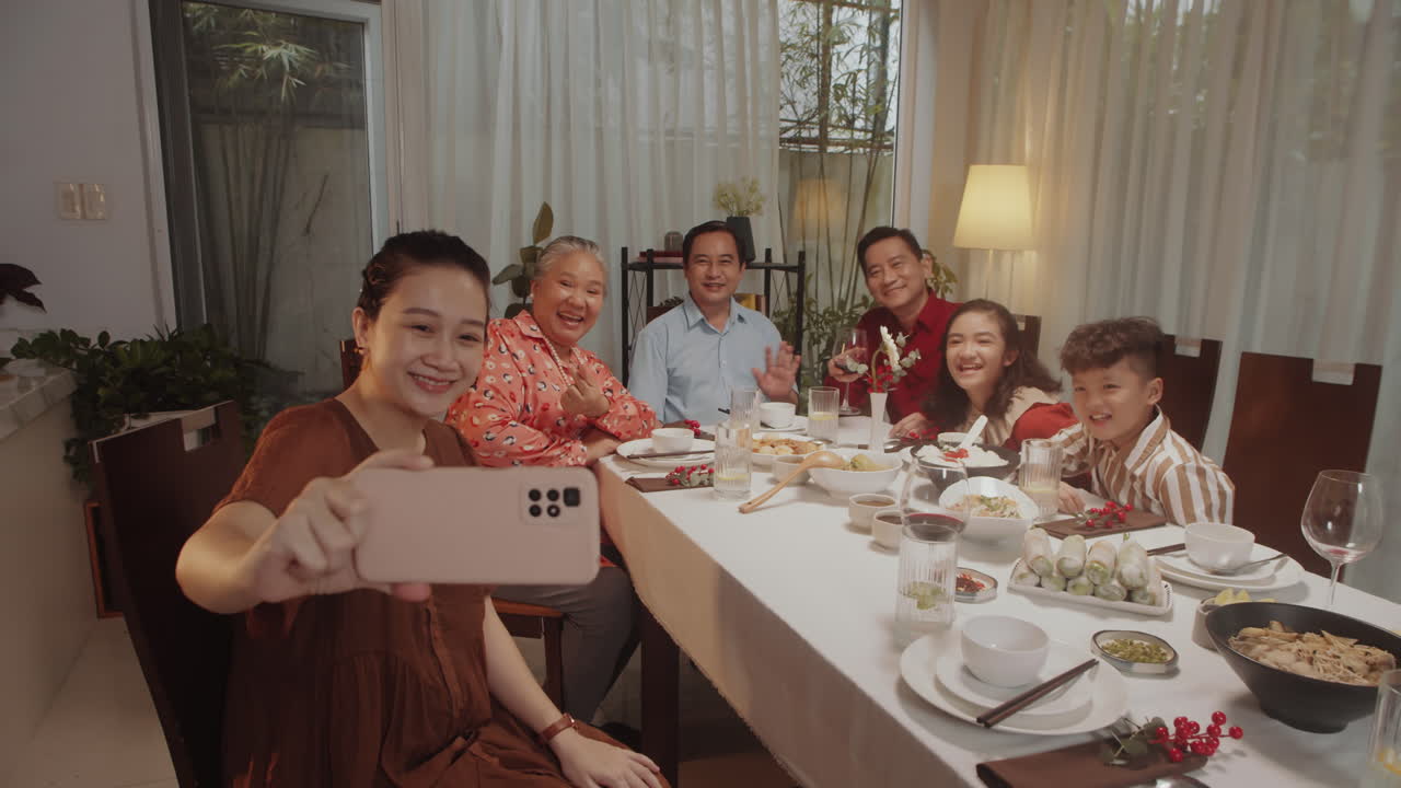 Woman Taking Selfie with Family Using Smartphone during Dinner
