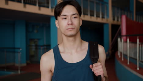 young man with backpack at the gym