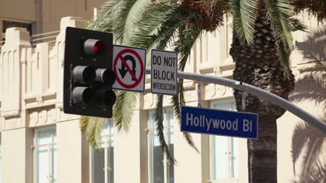 Long-lens-of-Hollywood-Boulevard-street-sign,-palm-tree-and-traffic-signs