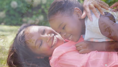 animation of african american mother and daughter embracing in park over leaves