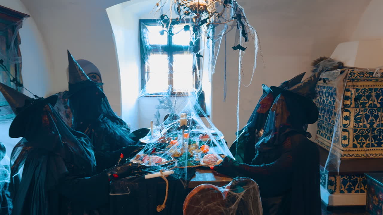 Entering the little room with four figures of four witches having festive dinner. Halloween decoration of the old castle.