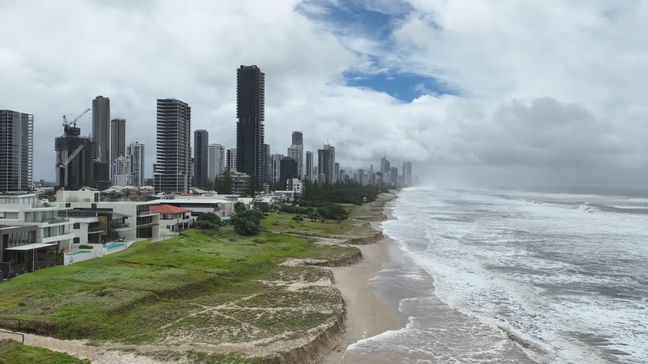 Drone flying along coastline towards Gold Coast Highrises during bad weather