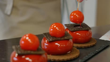 chef decorating red glaze cakes