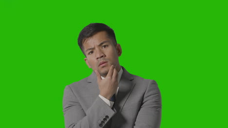 retrato de un hombre de negocios serio con traje pensando en una pantalla verde mirando la cámara 1