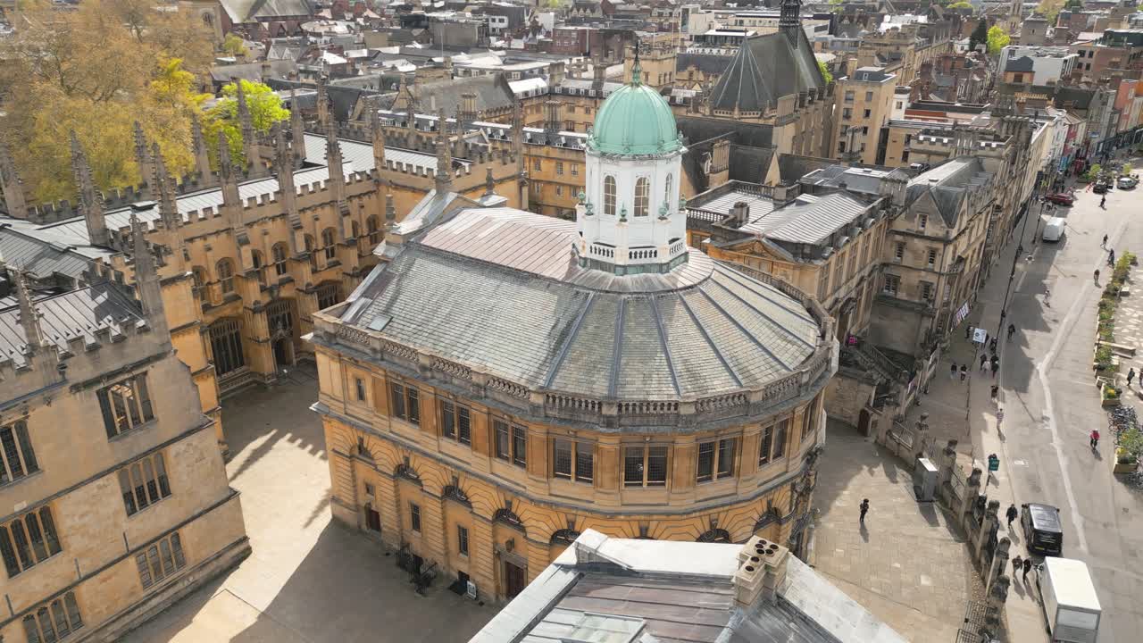 Aerial shot of the sun lit Sheldonian Theatre, birds flying around the beautiful english city of Oxford