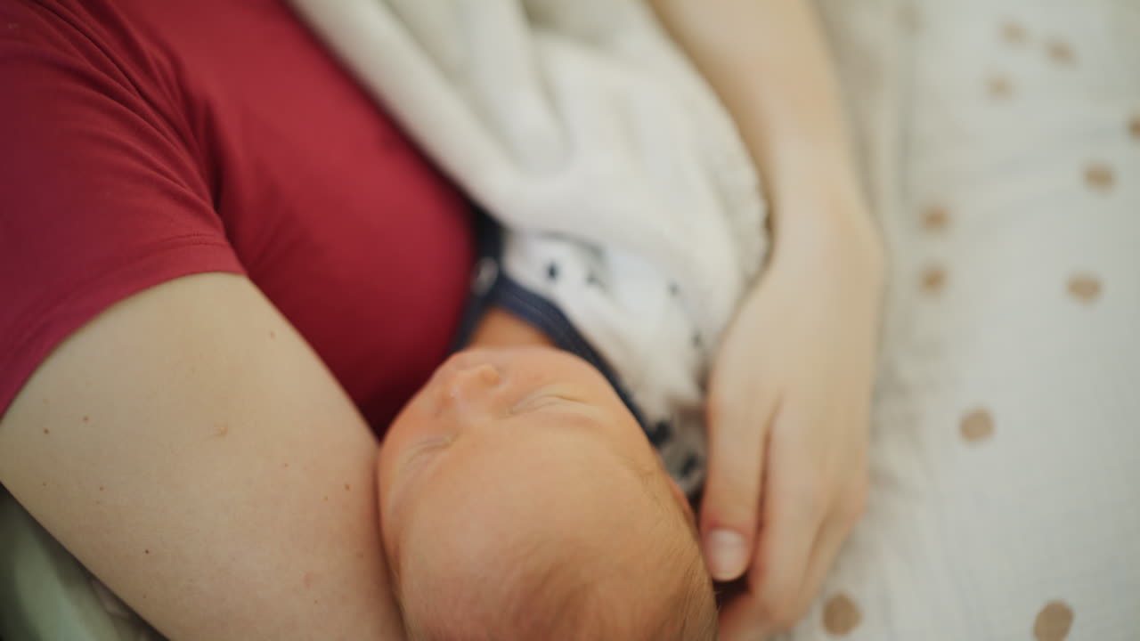 Primo piano di neonato che dorme accanto alla madre