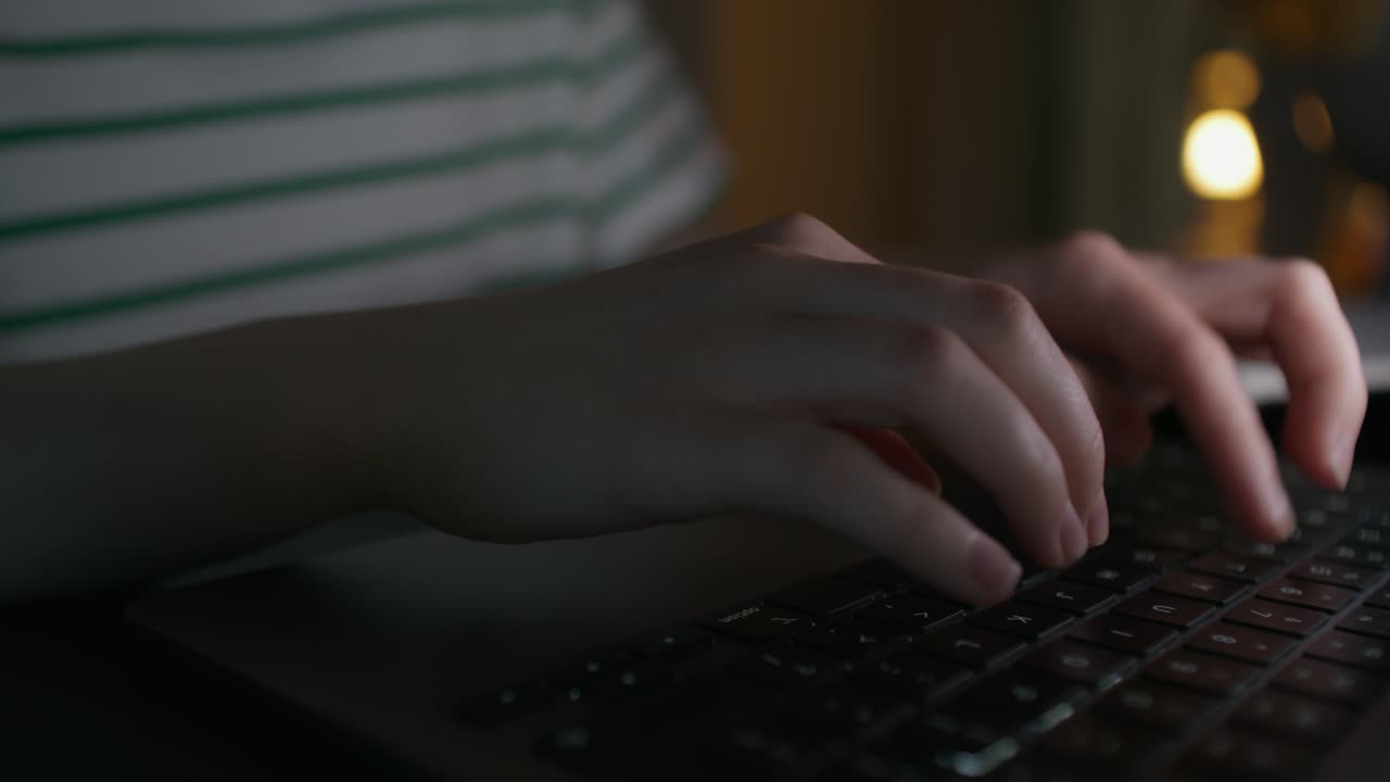 Persona che scrive su un portatile di notte