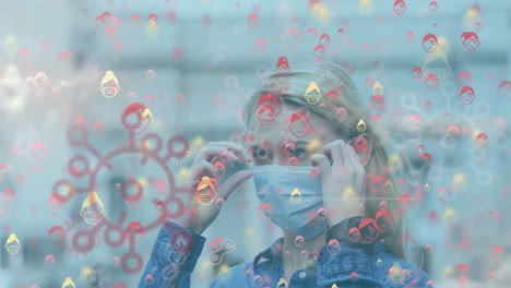 Animation-of-coronavirus-cells-over-woman-wearing-face-mask