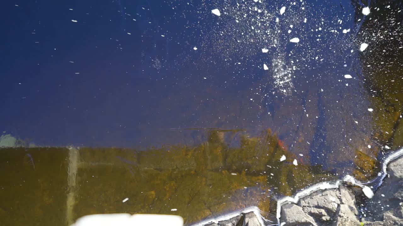 슬로우 모션으로 조각난 얼어붙은 호수 표면에 얼음을 떨어뜨리다