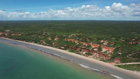 panning from right to left with drone on small paradise beach with green sea and calm waters in northeastern brazil