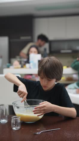 boy mixing ingredients in kitchen