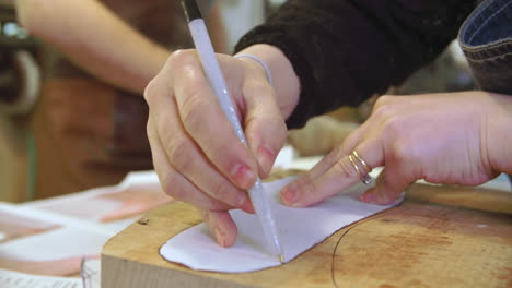 worker in bespoke shoemakers drawing template for last