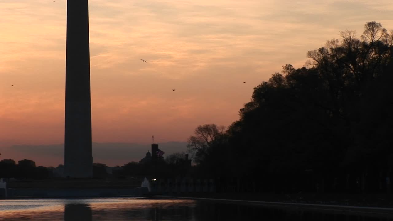 panorámica ascendente del monumento a washington recortada contra un cielo dorado
