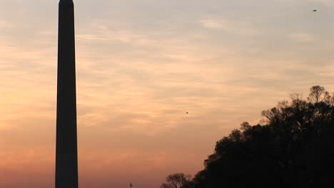 Pan-Hacia-Arriba-Del-Monumento-De-Washington-Silueta-Contra-Un-Cielo-Dorado