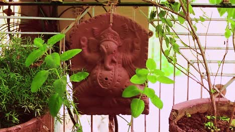 Estatua-Del-Dios-Hindú-Ganesha-Aislada-En-El-Jardín-Con-árbol-Tulsi-Para-Rezar-En-El-Día