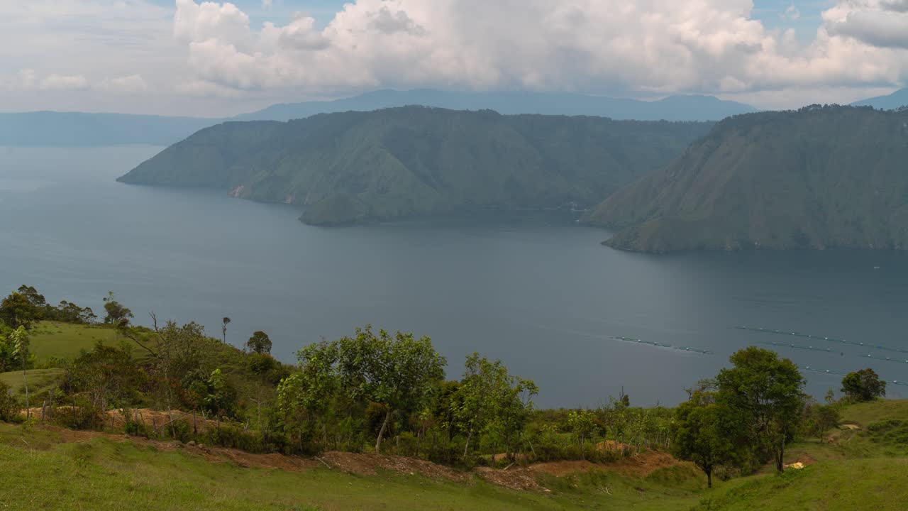 Panoramic view of Lake Toba, Sumatra with surrounding mountains and aquaculture farms