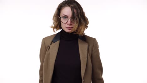 portrait of a young caucasian stressed girl shouting isolated over white background. slow motion. stressed and depressed woman in brown jacket desperately gesturing and shout