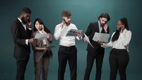 los compañeros de trabajo están de pie juntos hablando por teléfono y resolviendo algunas preguntas importantes