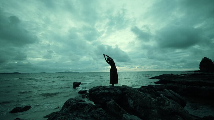 mujer practicando yoga en una playa al atardecer