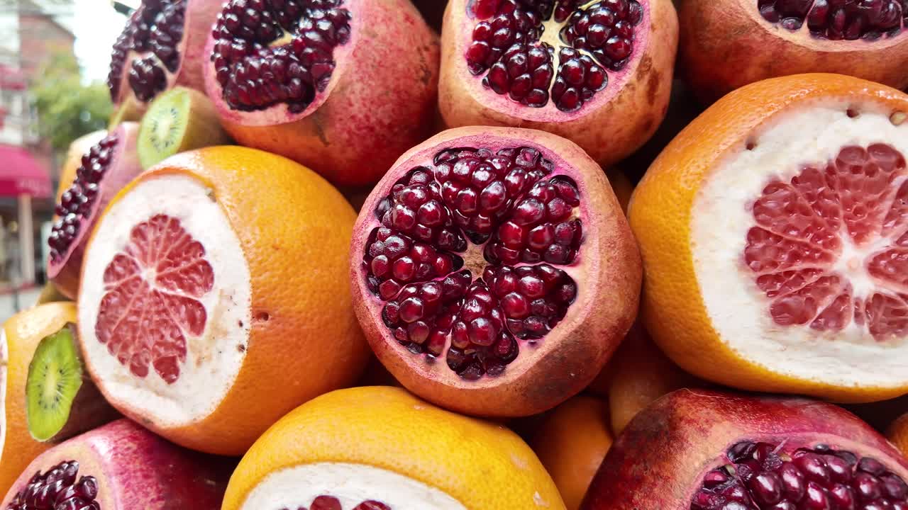 Nærbillede af friske granatæbler, appelsiner og kiwier