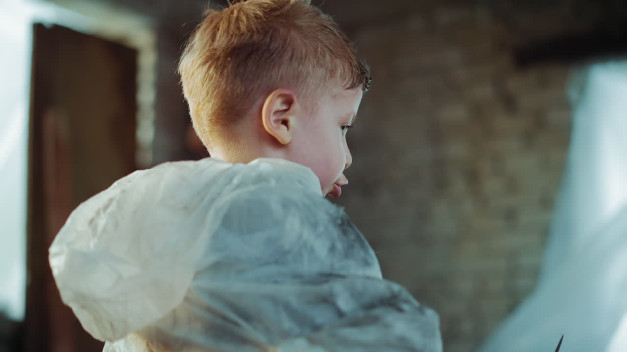 Close up of young boy wearing protective suit playing with pear knife indoors, child curiosity and danger contrasting innocence with risk, highlighting unsafe behavior