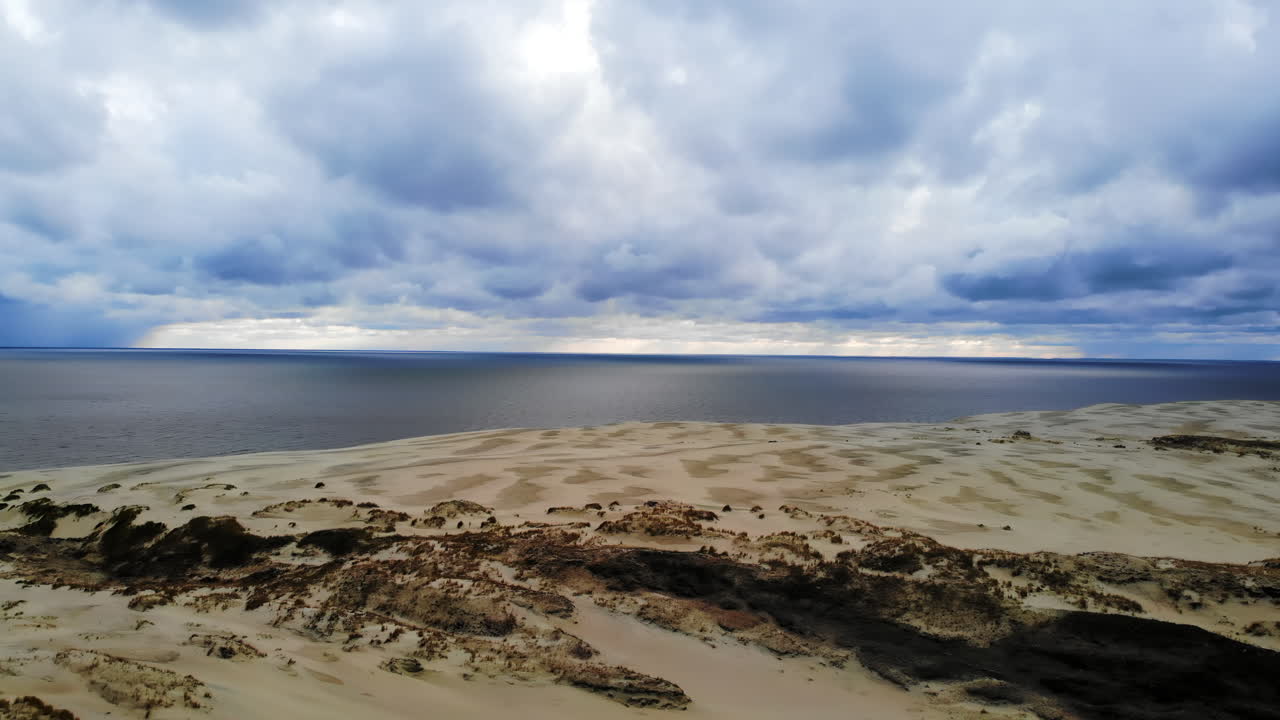 Dune landscape with sea and dramatic clouds