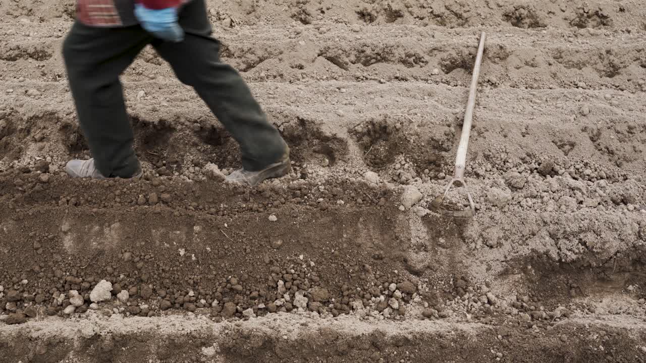 toma panorámica de un jardinero dejando la azada después de trabajar con el suelo