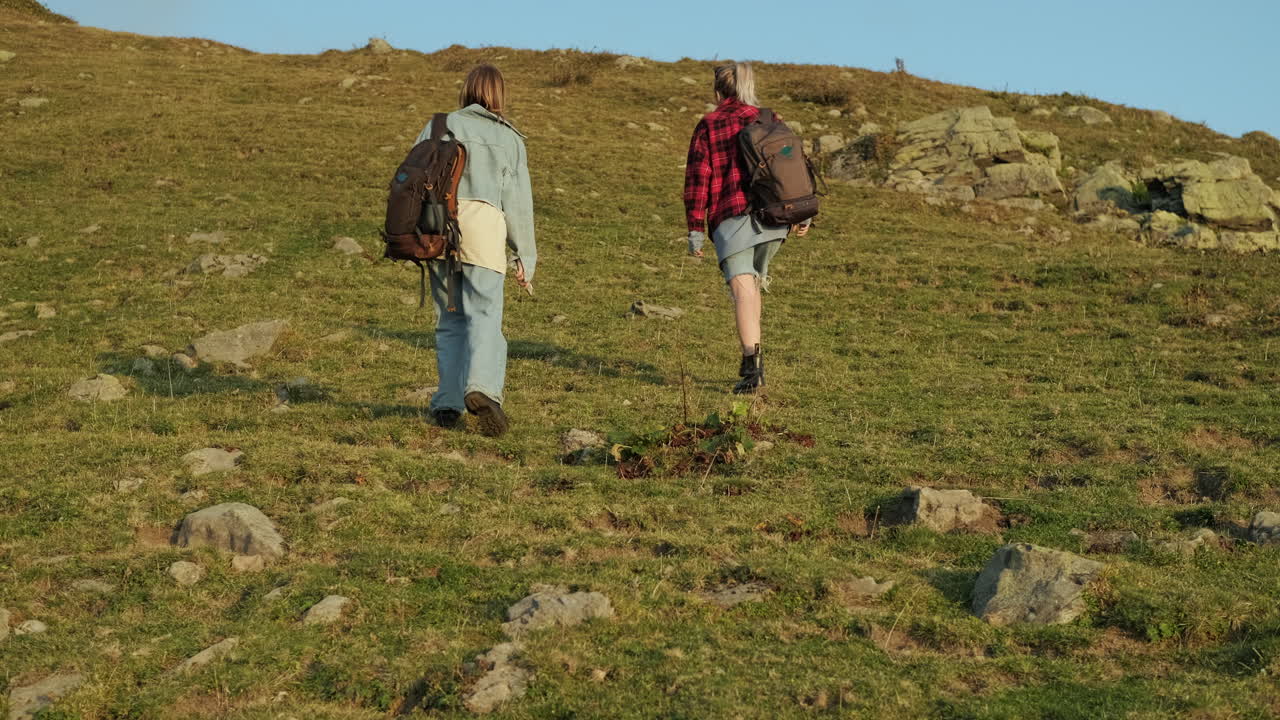 dos mujeres caminando por las montañas.
