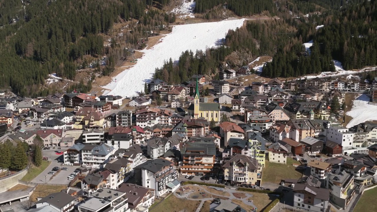 Orbit-Luftaufnahme des Skigebiets Ischgl in den österreichischen Alpen an einem sonnigen Tag.
