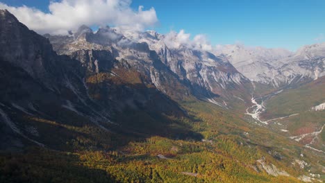 Alpine-landscape-with-valley-surrounded-by-high-mountains-under-clouds-in-Autumn
