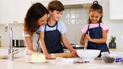 Mother-and-kids-preparing-cookies-in-kitchen